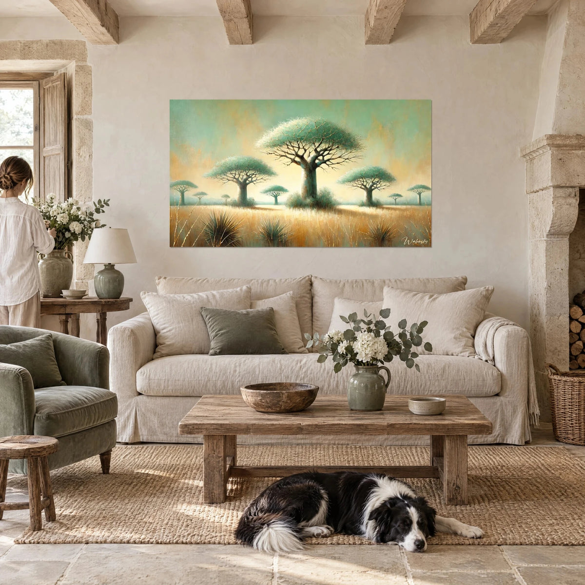 Tableau baobab géant à houppe vert d'eau, herbe dorée, ciel jaune pâle, chien de berger couché, au-dessus d'un canapé dans un salon lumineux