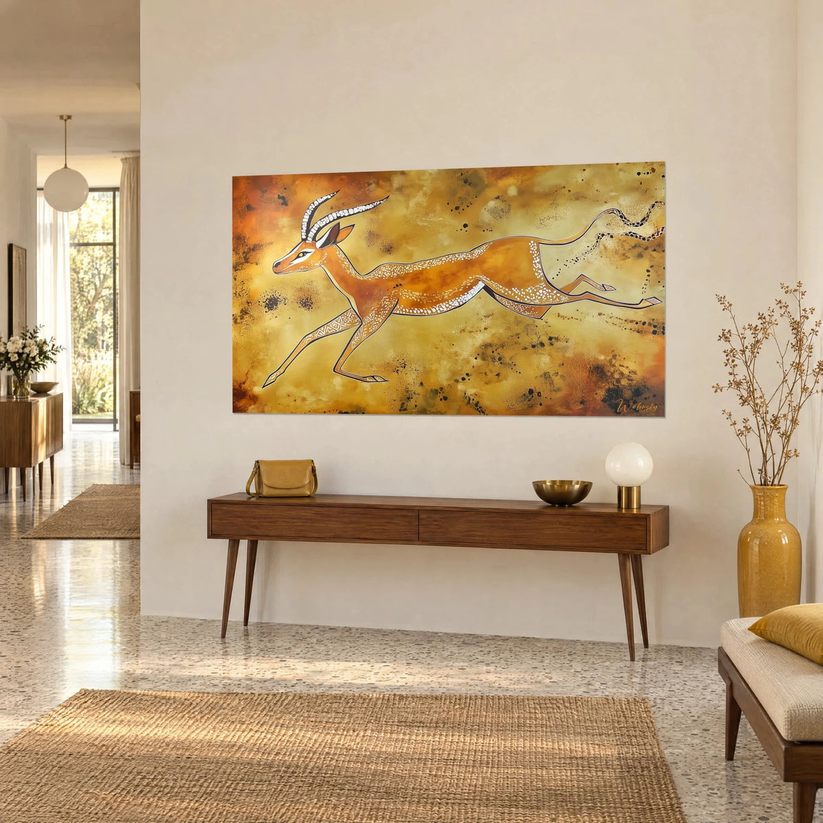 Tableau antilope en pleine course style rupestre, fond jaune moutarde et orange brûlé, au-dessus d'une console en bois