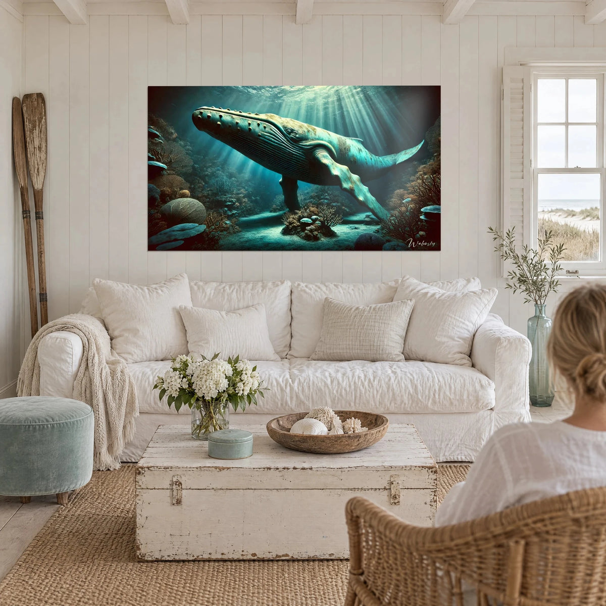 Gemälde Buckelwal türkis unter Lichtstrahlen, ockerfarbene Riffe, über einem Sofa in einem hellen Wohnzimmer
