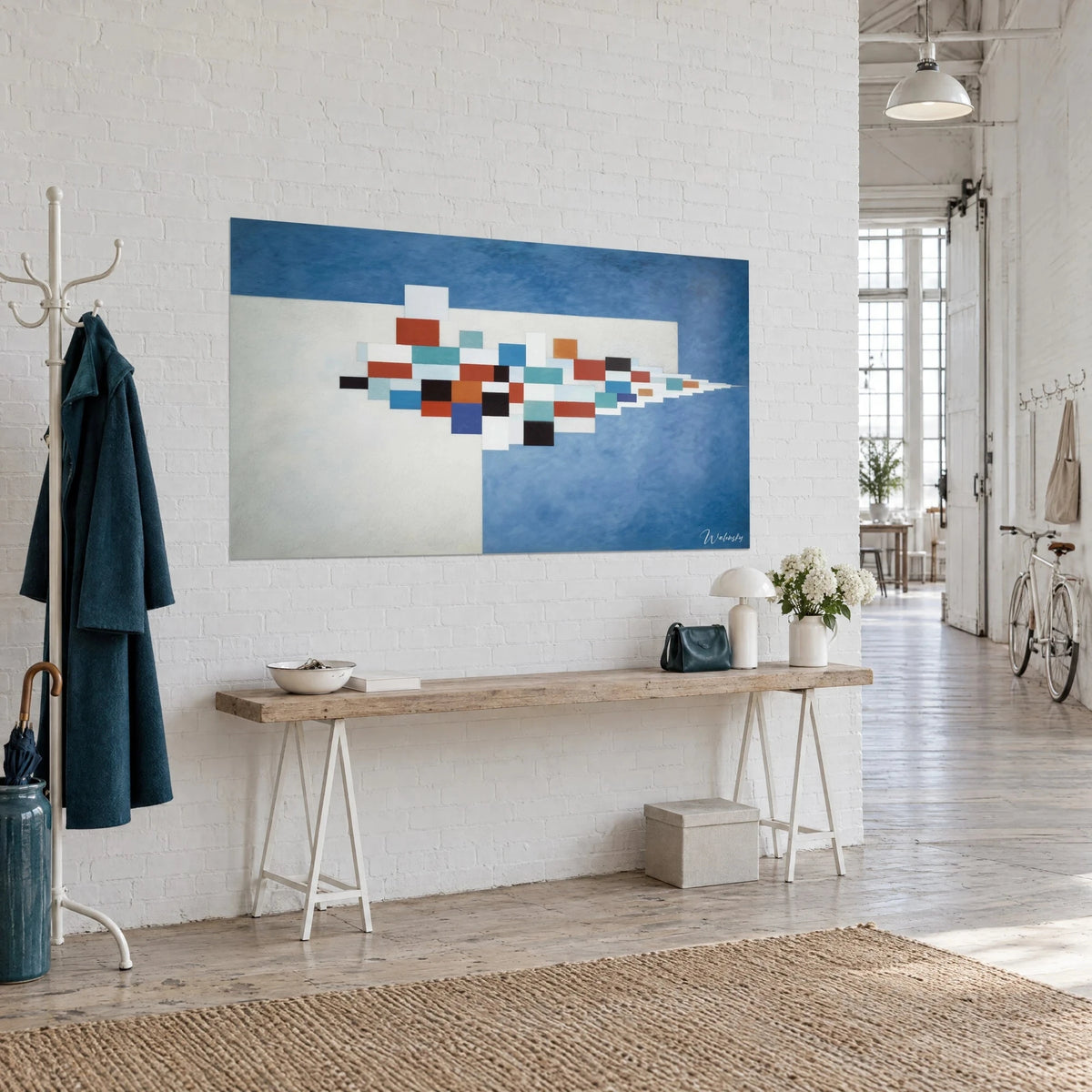Tableau mosaïque de blocs noirs, oranges et blancs pointée vers la droite sur fond bleu outremer, loft et console en bois