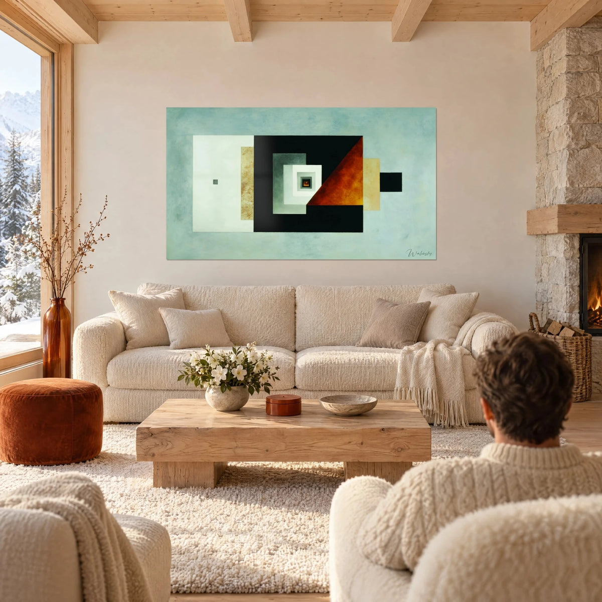 Tableau composition géométrique de carrés emboîtés noir et blanc, triangle rouille, fond bleu-gris, au-dessus d'un canapé dans un salon lumineux