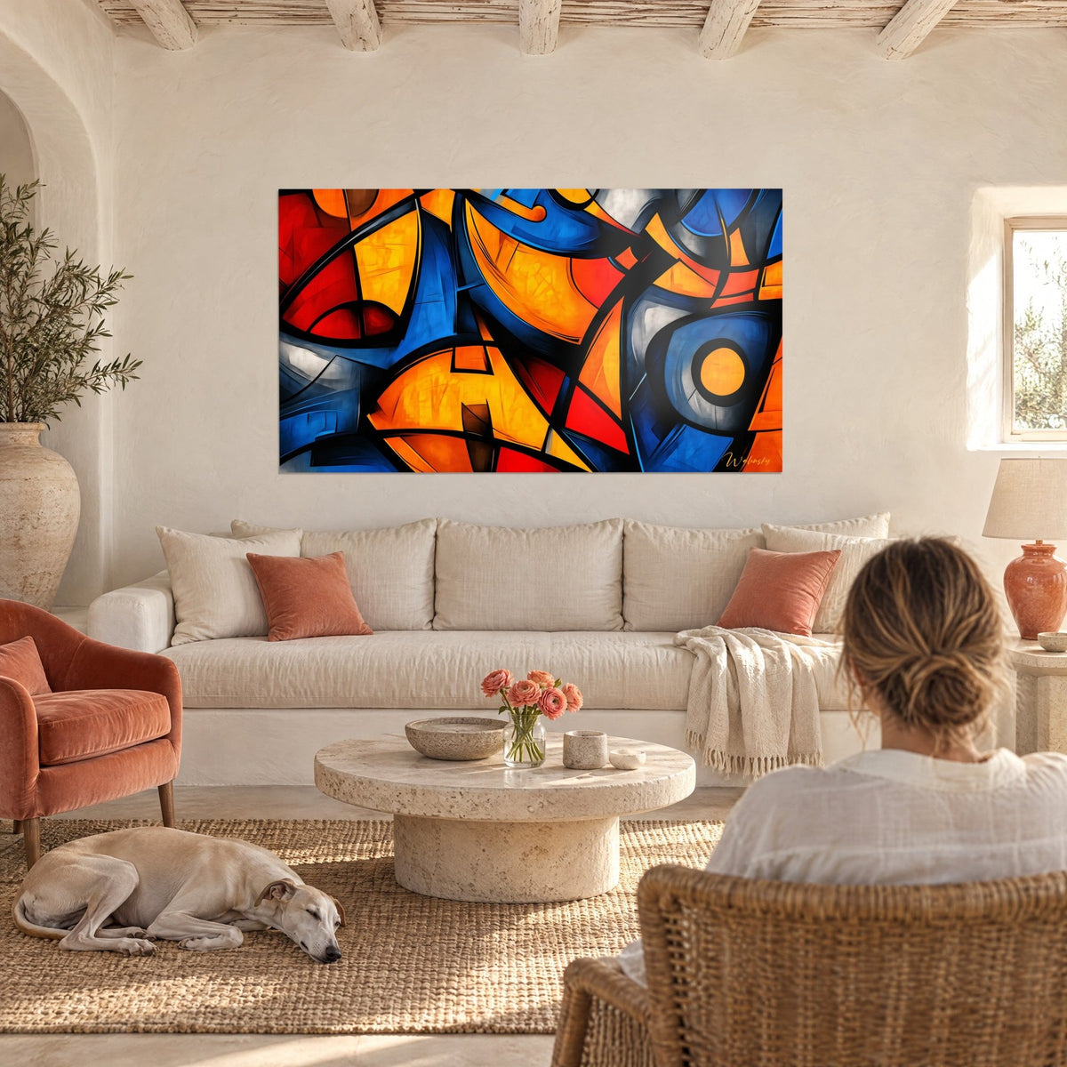 Wall art with bright orange, cobalt blue and red geometric shapes outlined in black, above a sofa in a bright living room