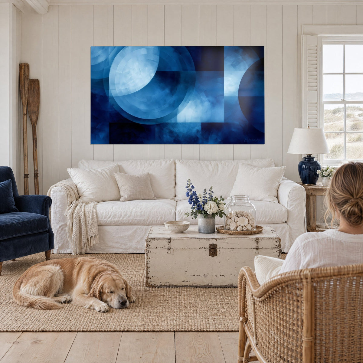 Wall art blue and navy circles, paint drips, retriever lying on the rug, above a sofa in a bright living room