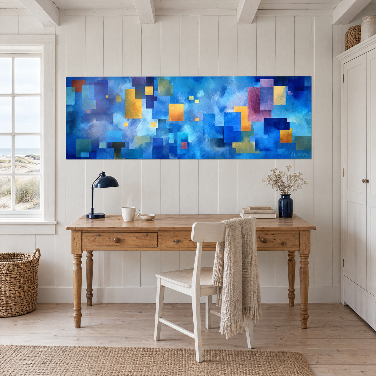 Gemälde Panorama aus farbigen Blöcken in Ultramarinblau und Orange vor weißer Wand, über einem Holzschreibtisch mit marineblauer Lampe