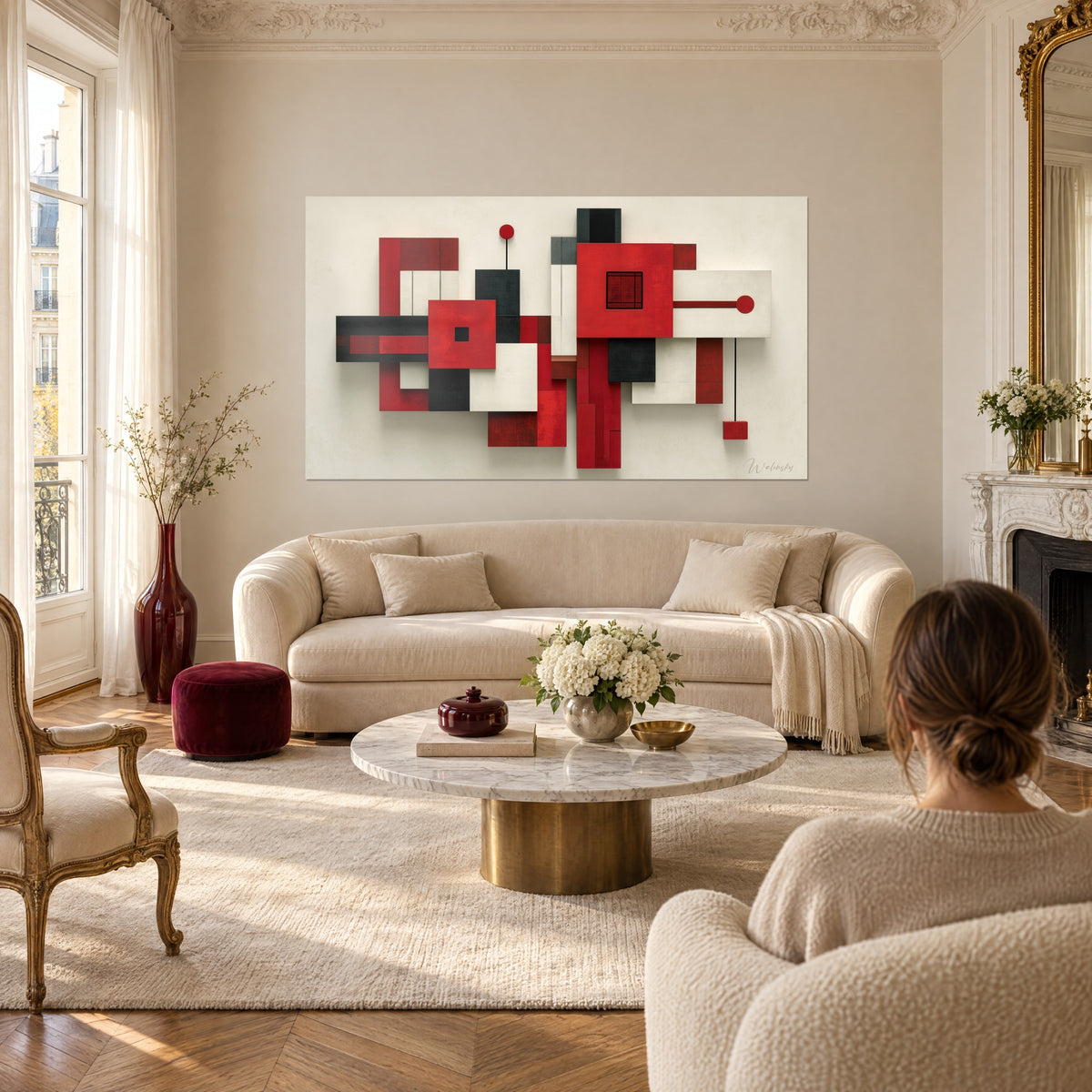 Quadro con blocchi geometrici in rilievo rosso vivo e antracite, linee nere e dischi, sopra un divano in un soggiorno luminoso