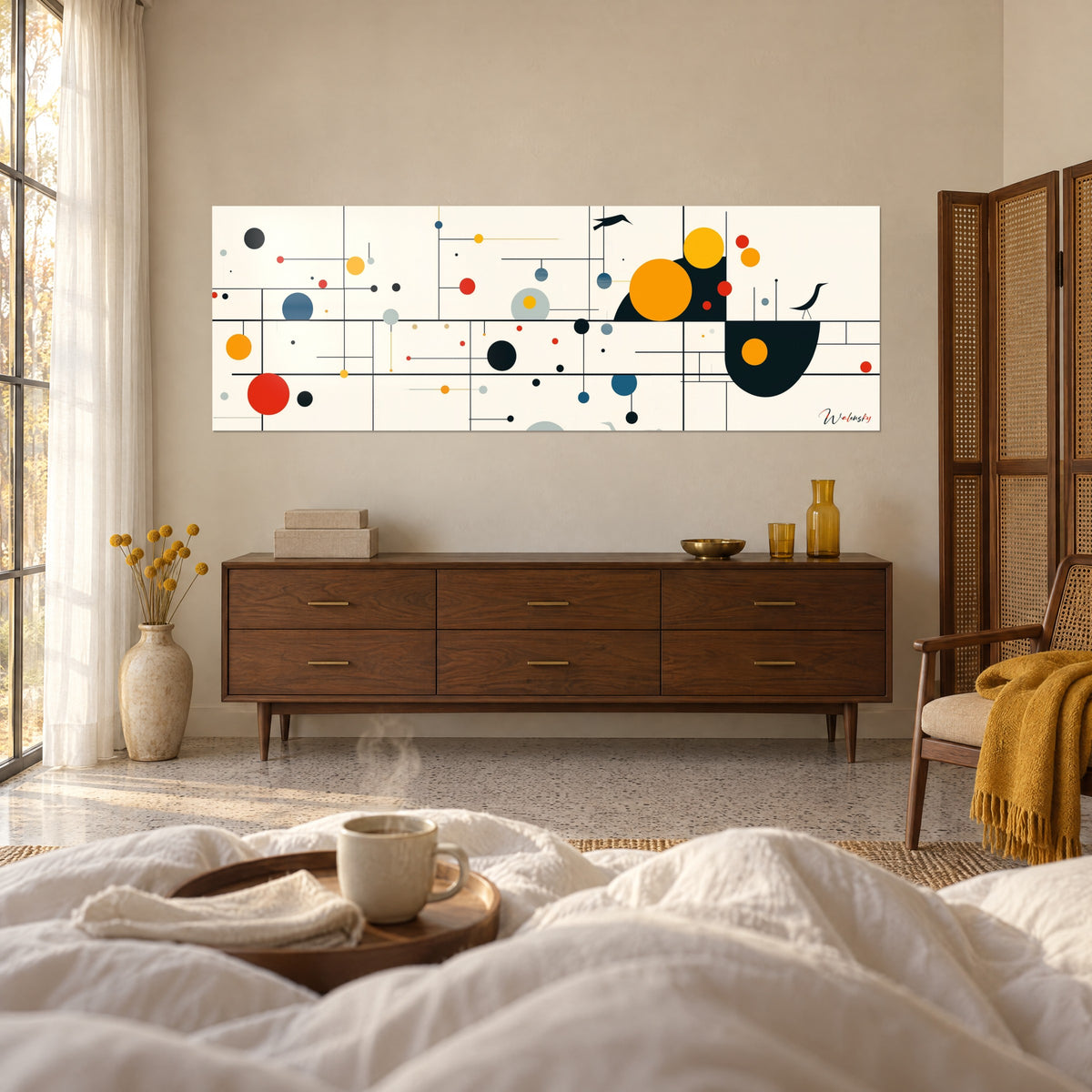 Cuadro de geometría poética con esferas rojas y amarillas sobre fondo marfil, encima de una cama en un dormitorio luminoso