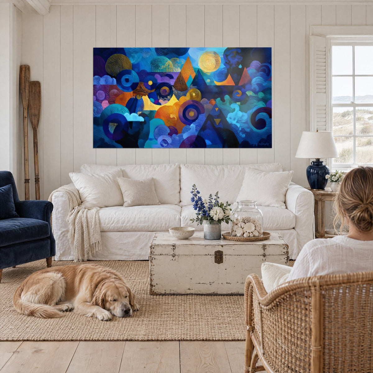Quadro cosmico di cerchi e piramidi in blu notte e arancio bruciato, luna dorata, sopra un divano in un soggiorno luminoso