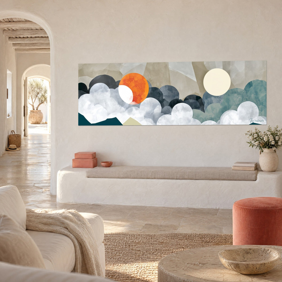 Wall art twin celestial bodies, orange disc and cream moon over blue-grey clouds, white wall, banquette and arched entryway