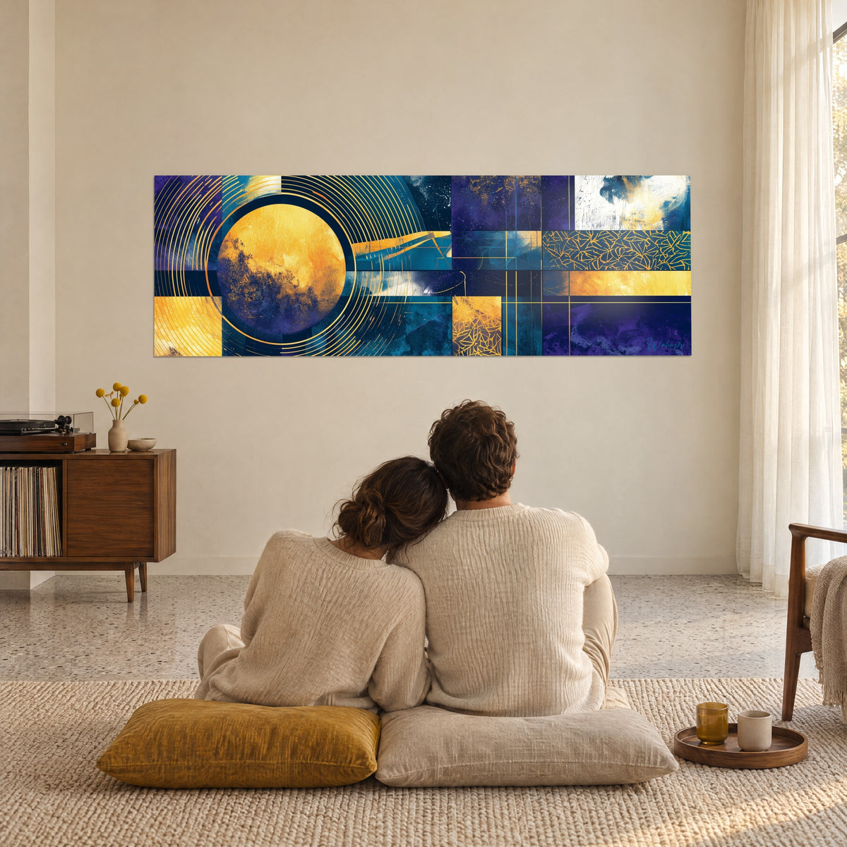 Quadro con un'astrazione cosmica in pannelli blu marino, viola e giallo miele, cerchio centrale radiante, coppia seduta davanti alla parete