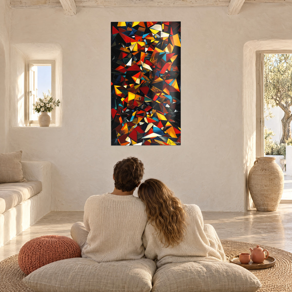 Tableau fragments anguleux jaune, rouge et turquoise sur noir, couple de dos sur des coussins, salon méditerranéen