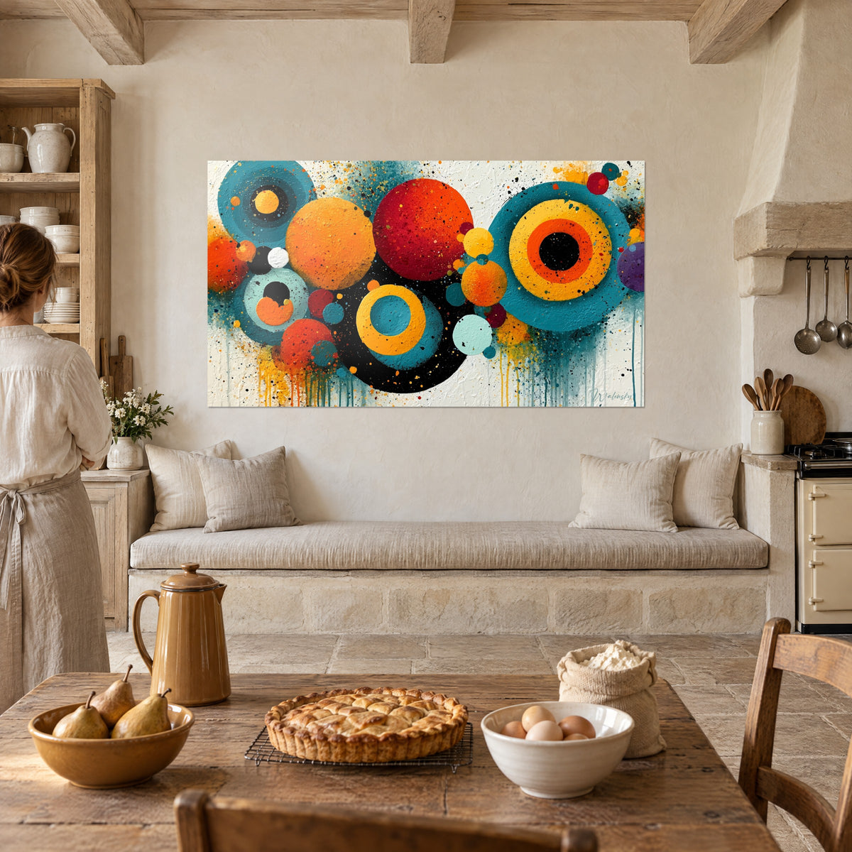 Schilderij met kleurrijke geometrische bellen in rood, geel en turquoise op een getextureerde witte achtergrond, vrouw van achteren, keuken, stenen schouwen