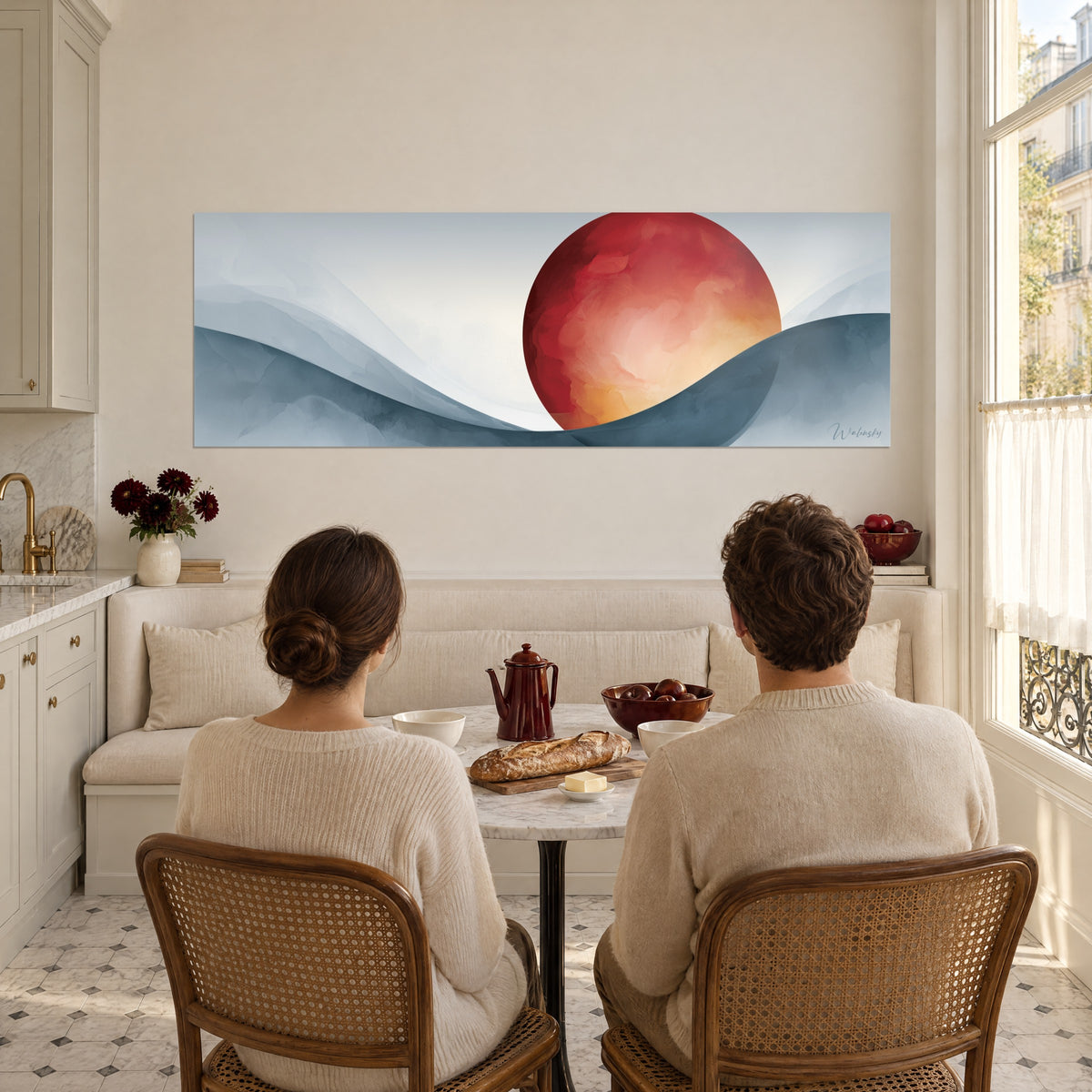 Quadro sfera cremisi sfumata in pesca e oro, curve blu acciaio, di fronte a una coppia seduta a tavola in una cucina assolata