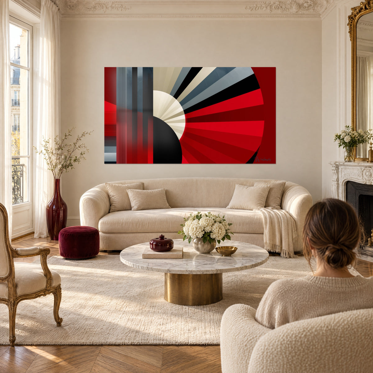 Tableau éventail géométrique aux rayons rouges et gris, demi-disque noir et ivoire, au-dessus d'un canapé dans un salon lumineux