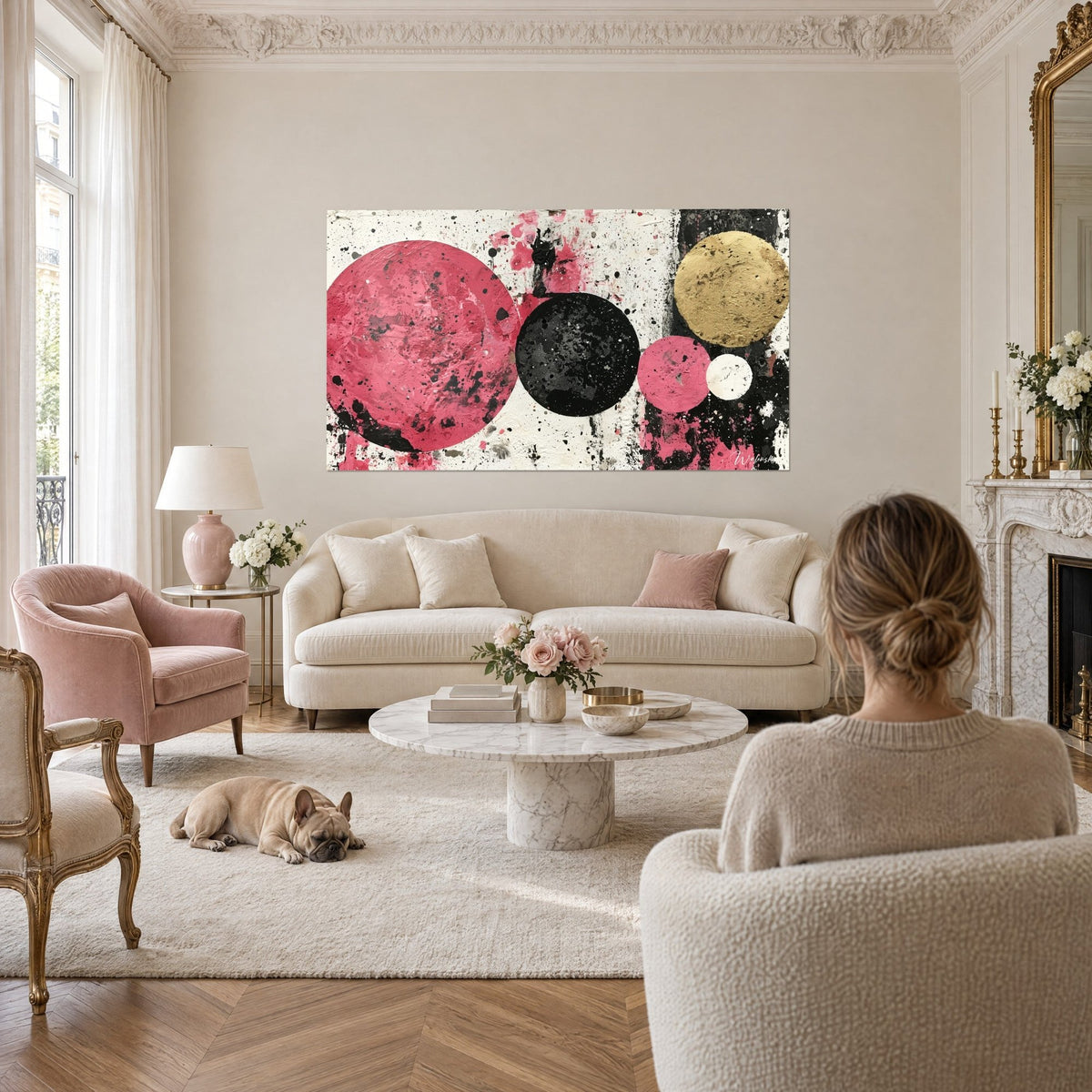 Cuadro con discos rosa frambuesa y negro mate rodeados de salpicaduras de pintura, sobre un sofá en un salón luminoso