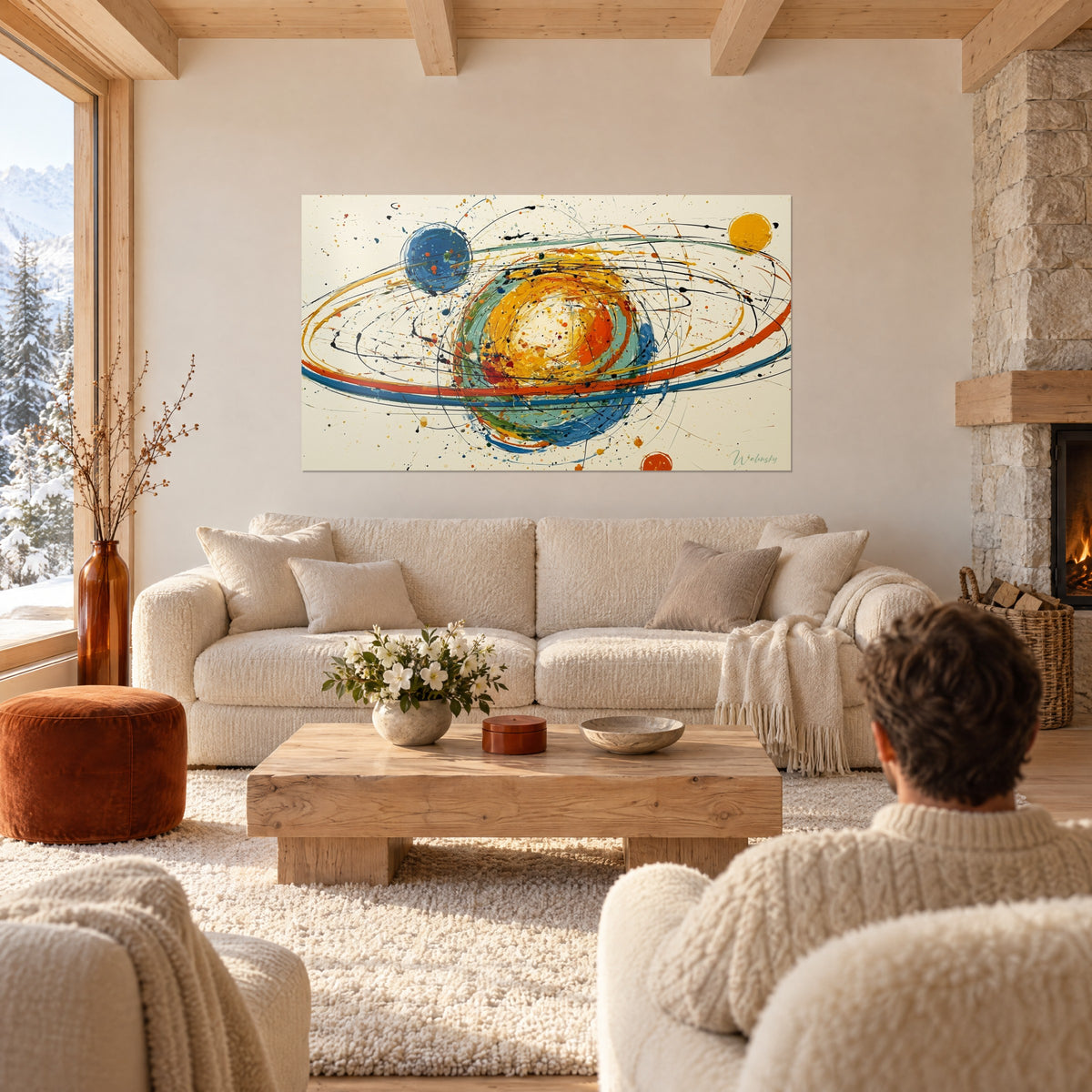 Tableau planète aux anneaux orange et bleus sur fond crème, éclaboussures noires, au-dessus d'un canapé dans un salon lumineux