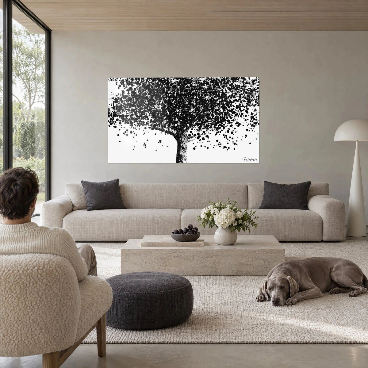 Schilderij pointillistische boom met zwarte stippen op witte achtergrond, donkere stam, boven een bank in een lichte woonkamer