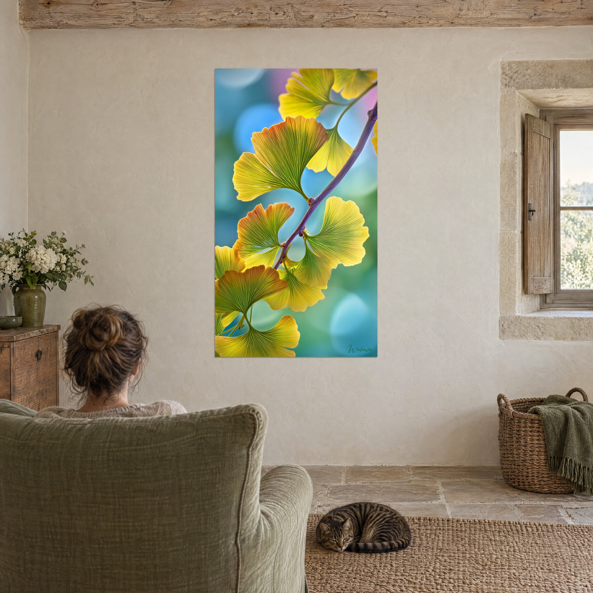 Gemälde herbstlicher Ginkgo, goldene und grüne Blätter auf himmelblauem Hintergrund, gegenüber einem salbeigrünen Sessel und einer getigerten Katze