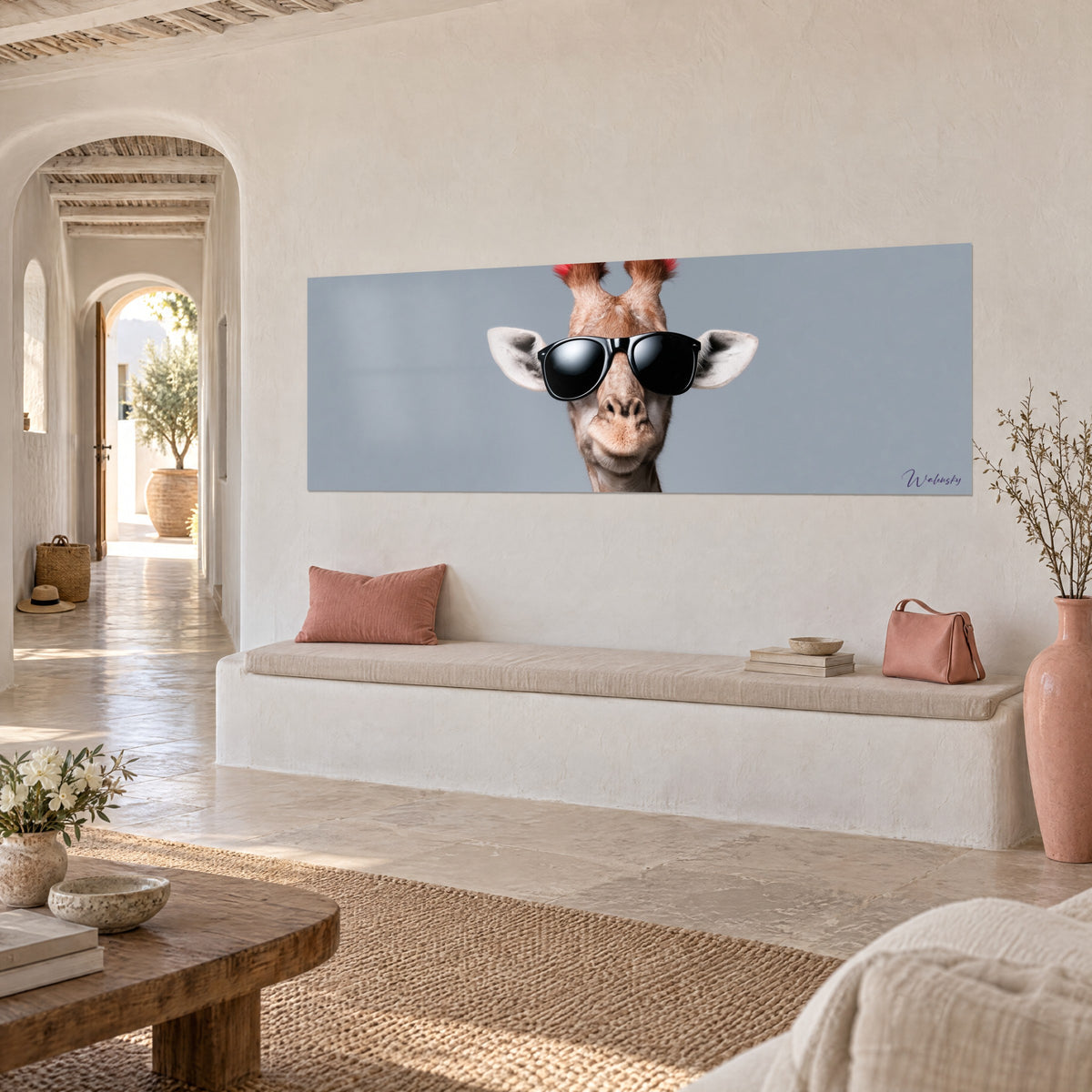 Tableau portrait de girafe cool, cornes teintées de rouge sur fond gris-bleu, mur crème d'une maison méditerranéenne en pierre claire