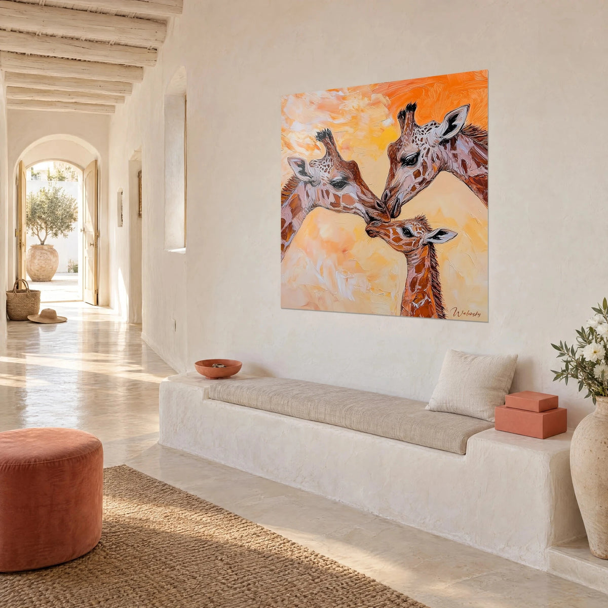 Wall art baby giraffe nose to nose with its parents, honey and burnt orange tones, whitewashed wall of a Mediterranean house