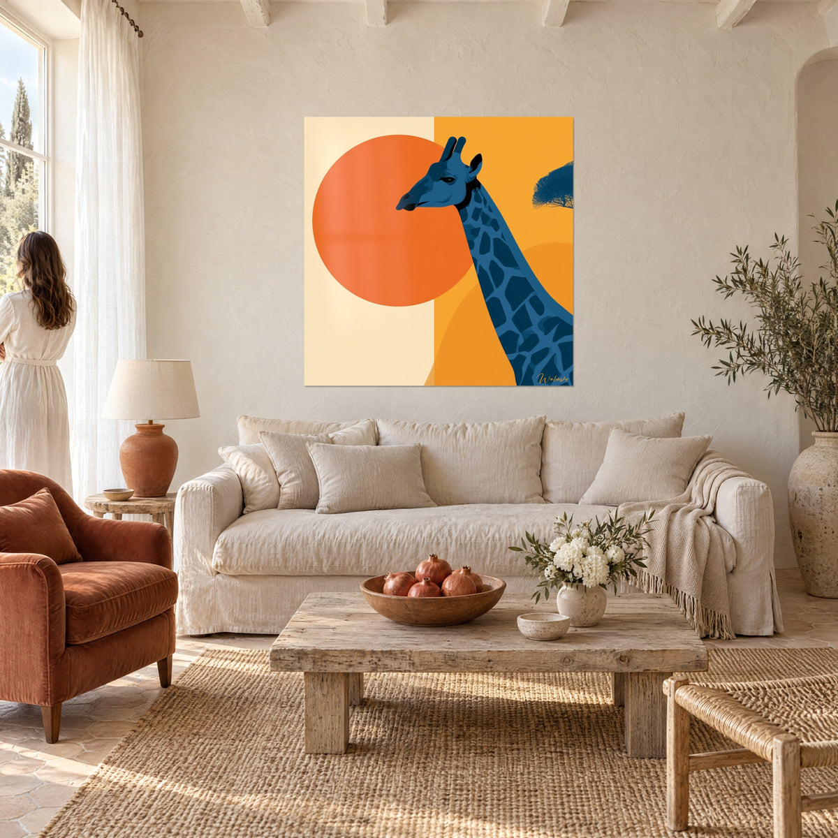 Quadro giraffa blu notte davanti a un disco arancione su sfondo crema e ocra, donna di spalle, sopra un divano in un soggiorno luminoso
