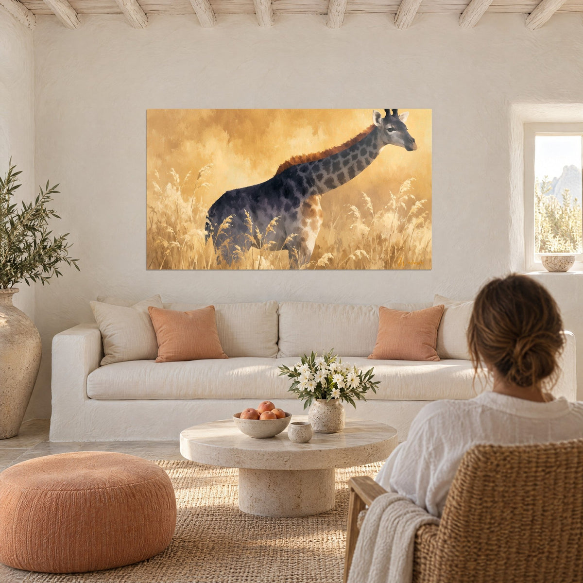 Gemälde Giraffe mit anthrazitfarbenem Fell in goldenem Gras, orangefarbener Hals; Frau von hinten über einem Sofa in einem hellen Wohnzimmer