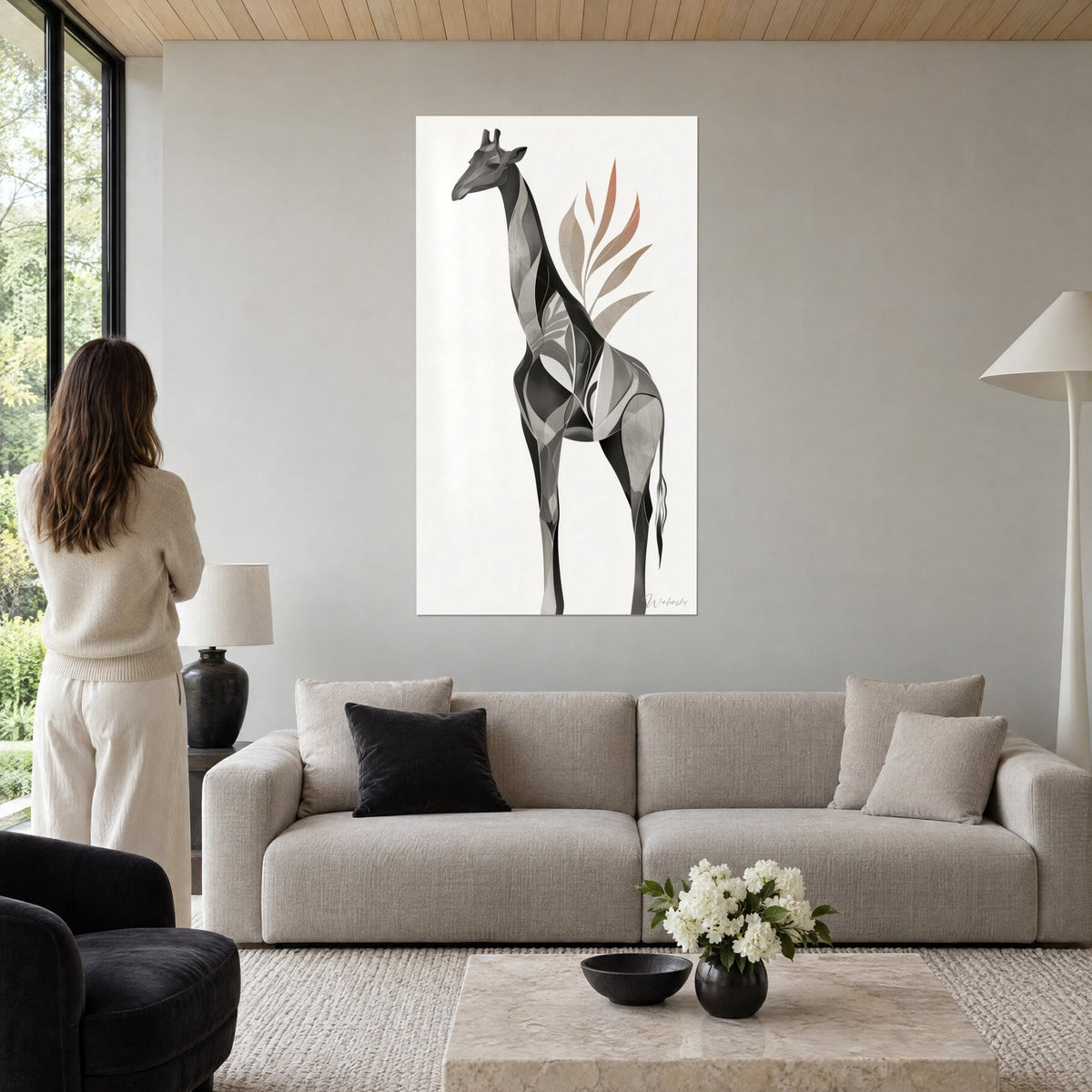 Gemälde Giraffe in Grau mit geometrischen Facetten, terrakottafarbene und sandfarbene Blätter auf elfenbeinfarbenem Hintergrund, über einem Sofa in einem hellen Wohnzimmer