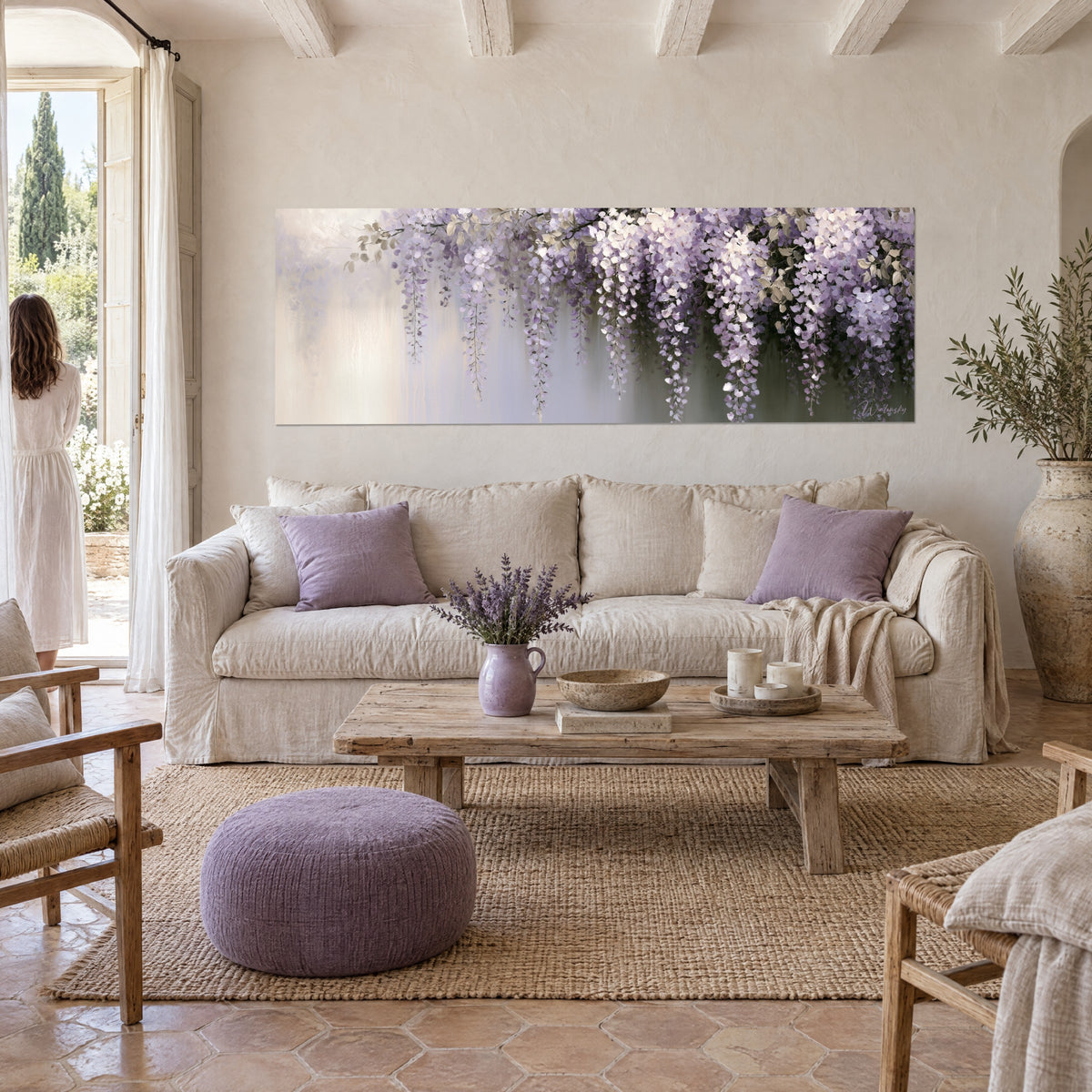 Wall art wisteria in mauve and white clusters on a pearl grey background, a woman seen from behind, above a sofa in a bright living room