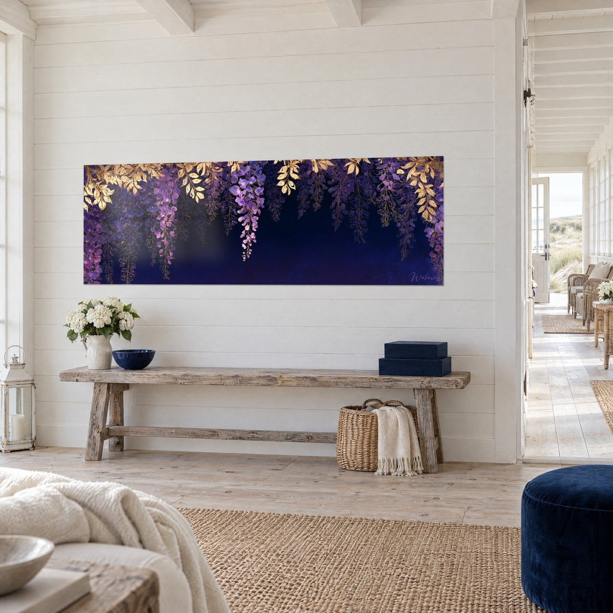 Wall art hanging lilac clusters beneath golden foliage, deep midnight blue, three-quarter view of a white wall in a seaside house