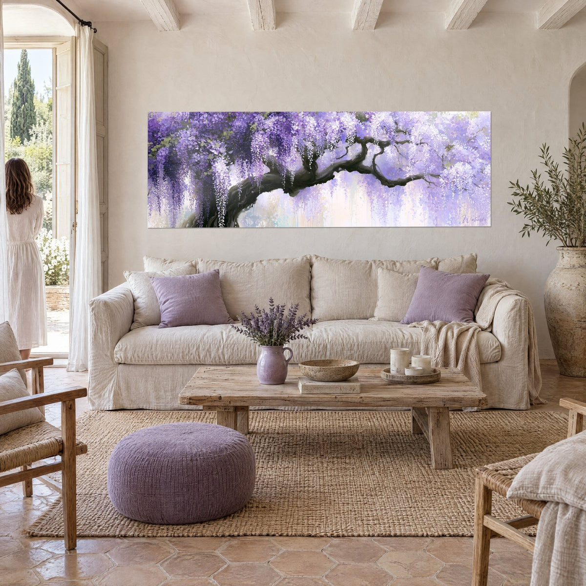 Wall art wisteria in lilac and white clusters on a black arched branch, two people seen from behind, above a sofa in a bright living room