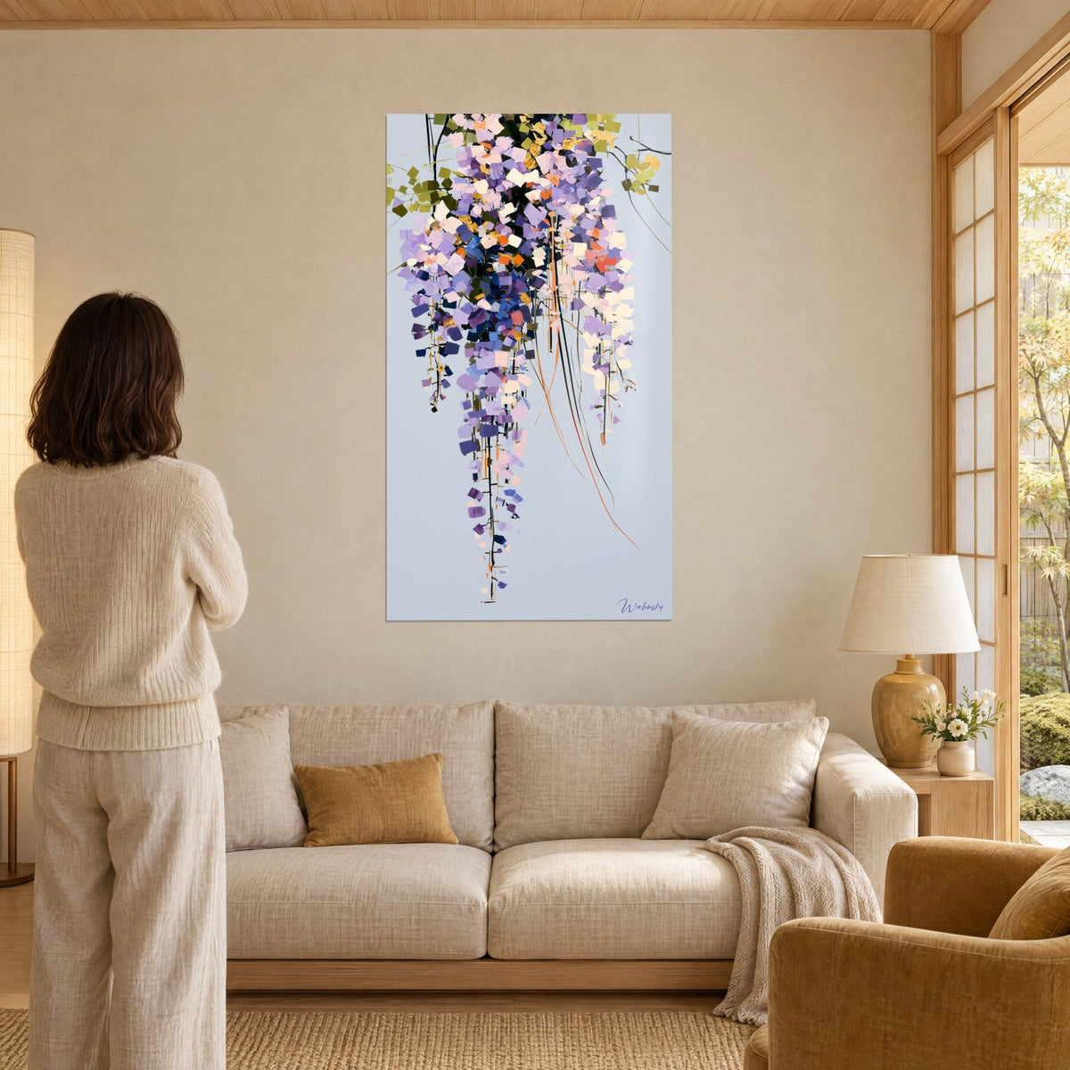 Quadro glicine in grappoli malva e rosa, tocchi arancio su fondo grigio-azzurro, sopra un divano in un soggiorno luminoso