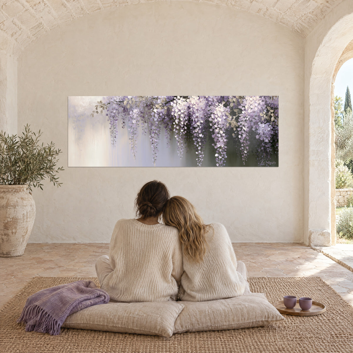 Wall art curtain of violet and white wisteria on a pearl background, two women in ecru jumpers seated from behind on a rug