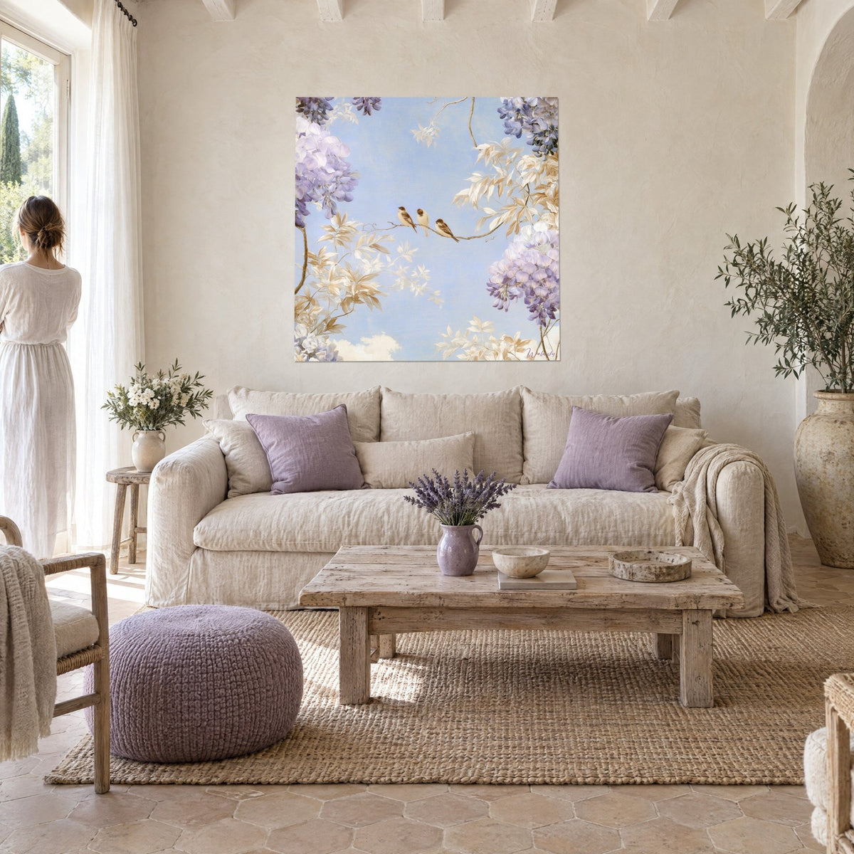 Gemälde aufgereihter Spatzen auf einem Zweig, himmelblauer Hintergrund mit mauvefarbenen Glyzinien, Rückenansicht einer Silhouette, über einem Sofa in einem hellen Wohnzimmer