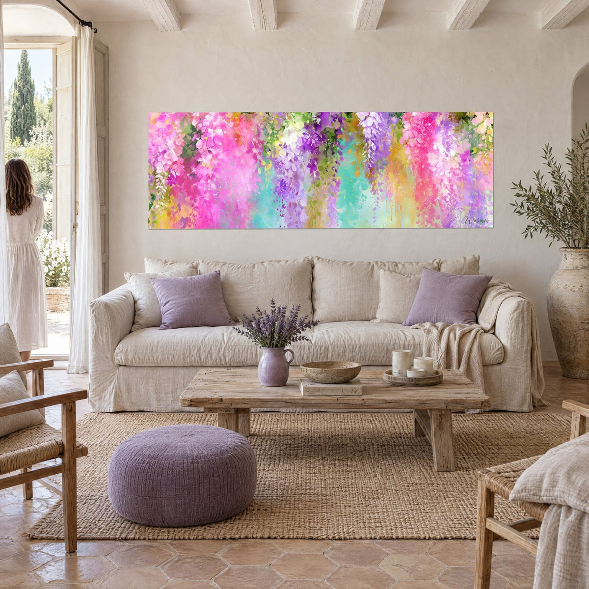 Wall art with dripping clusters of pink and turquoise wisteria, purple and yellow accents, above a sofa in a bright living room