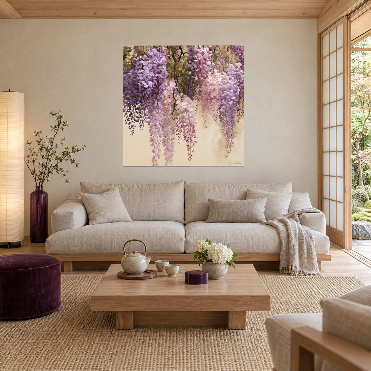 Schilderij blauweregen in trossen mauve en poederroze op beige achtergrond, olijfgroen gebladerte, boven een bank in een lichte woonkamer
