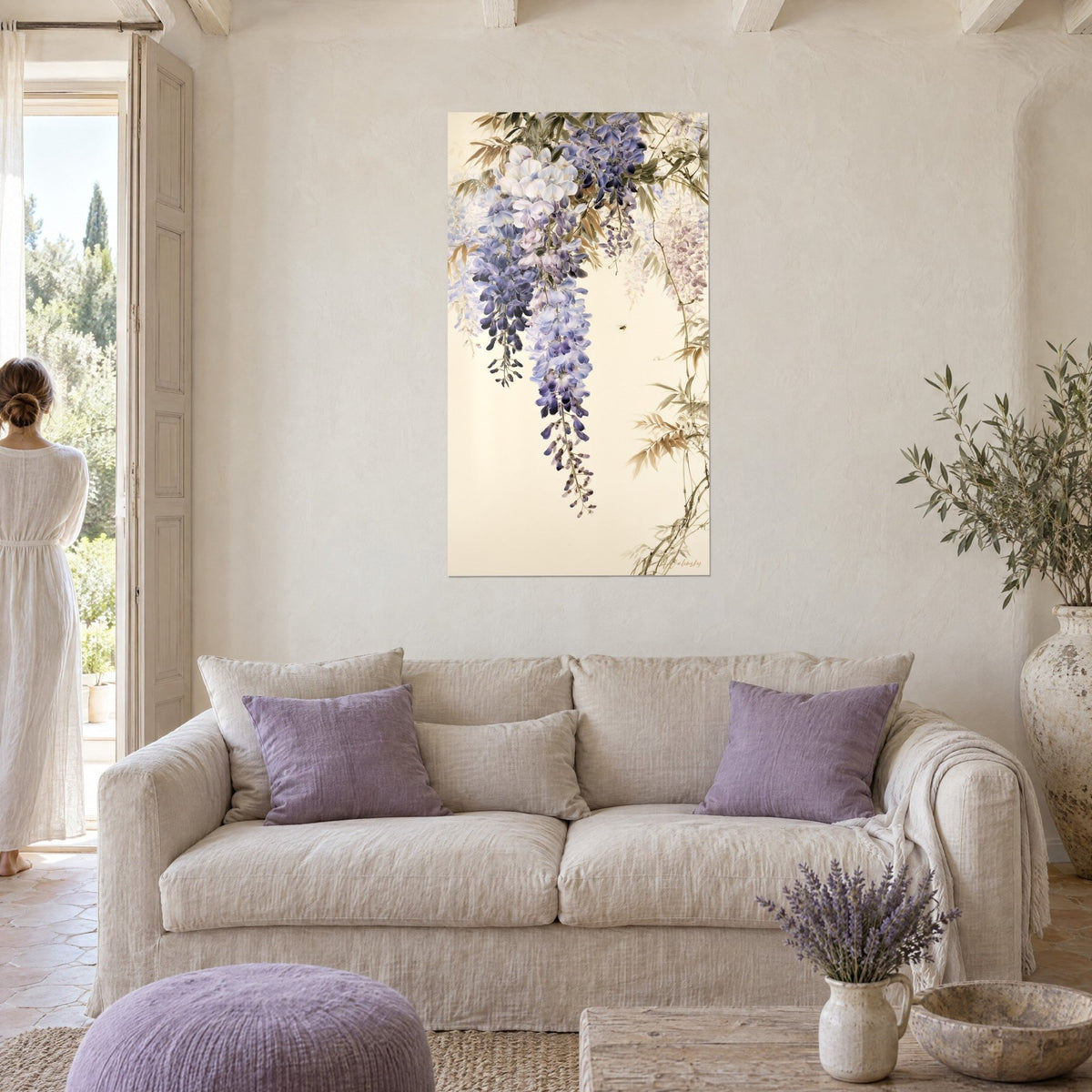 Wall art of lilac and white wisteria clusters, tiny bee on cream background, above a sofa in a bright living room