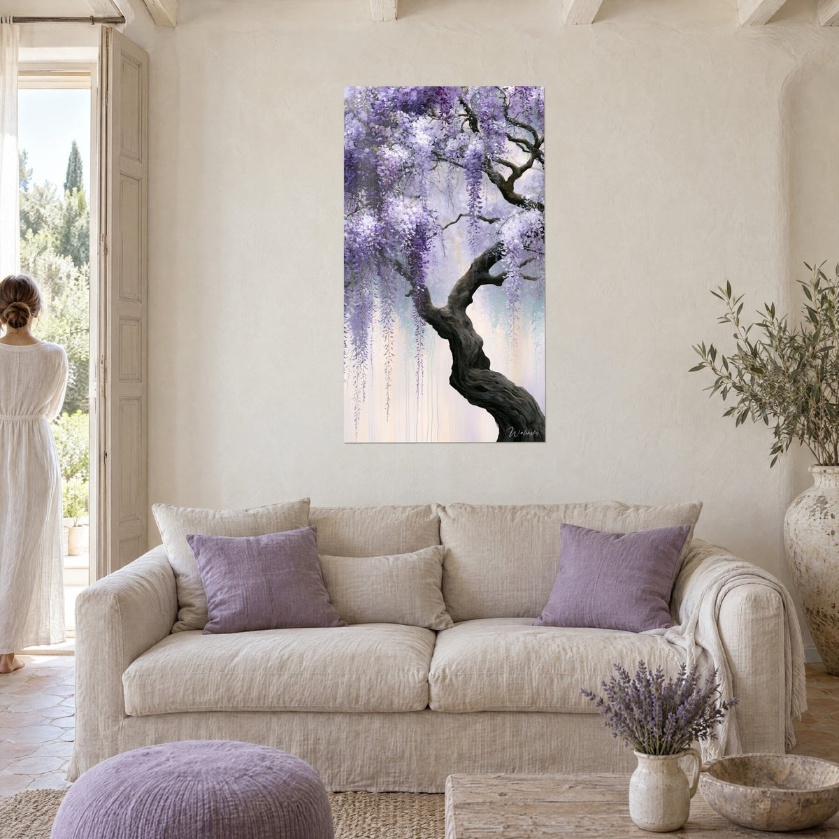 Wall art wisteria in purple and white clusters on a gnarled trunk, on the wall of a Provençal farmhouse, above a sofa in a bright living room