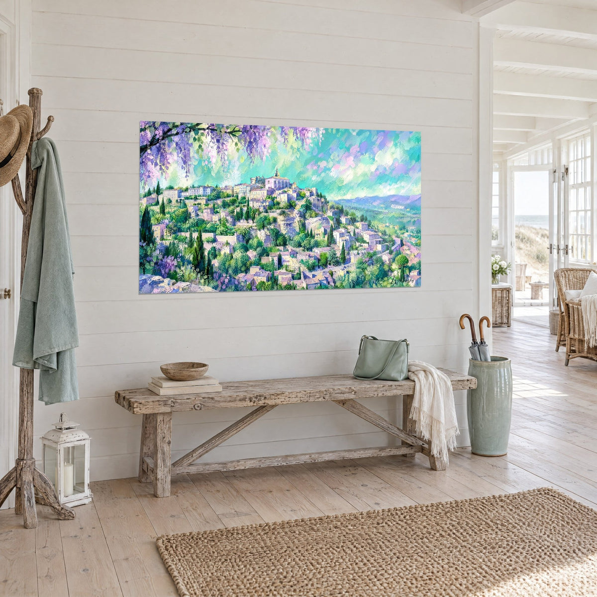 Wall art medieval town of Gordes on its green hill, white bell tower, turquoise sky streaked with pink, wood-paneled wall and rustic bench