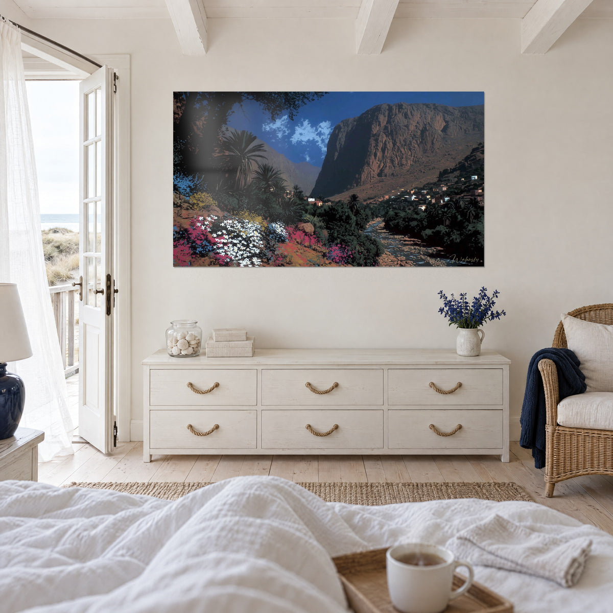Tableau village berbère rose au pied d'un massif rouge, ciel bleu profond, au-dessus d'un lit dans une chambre claire