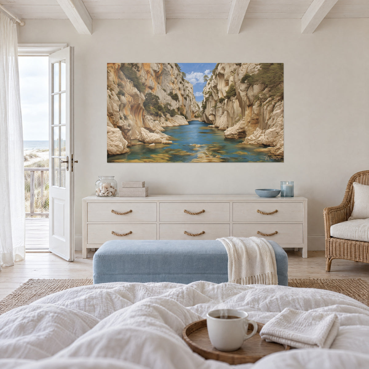 Wall art rocky pass with sand and orange cliffs, deep blue water, white clouds, above a bed in a light bedroom