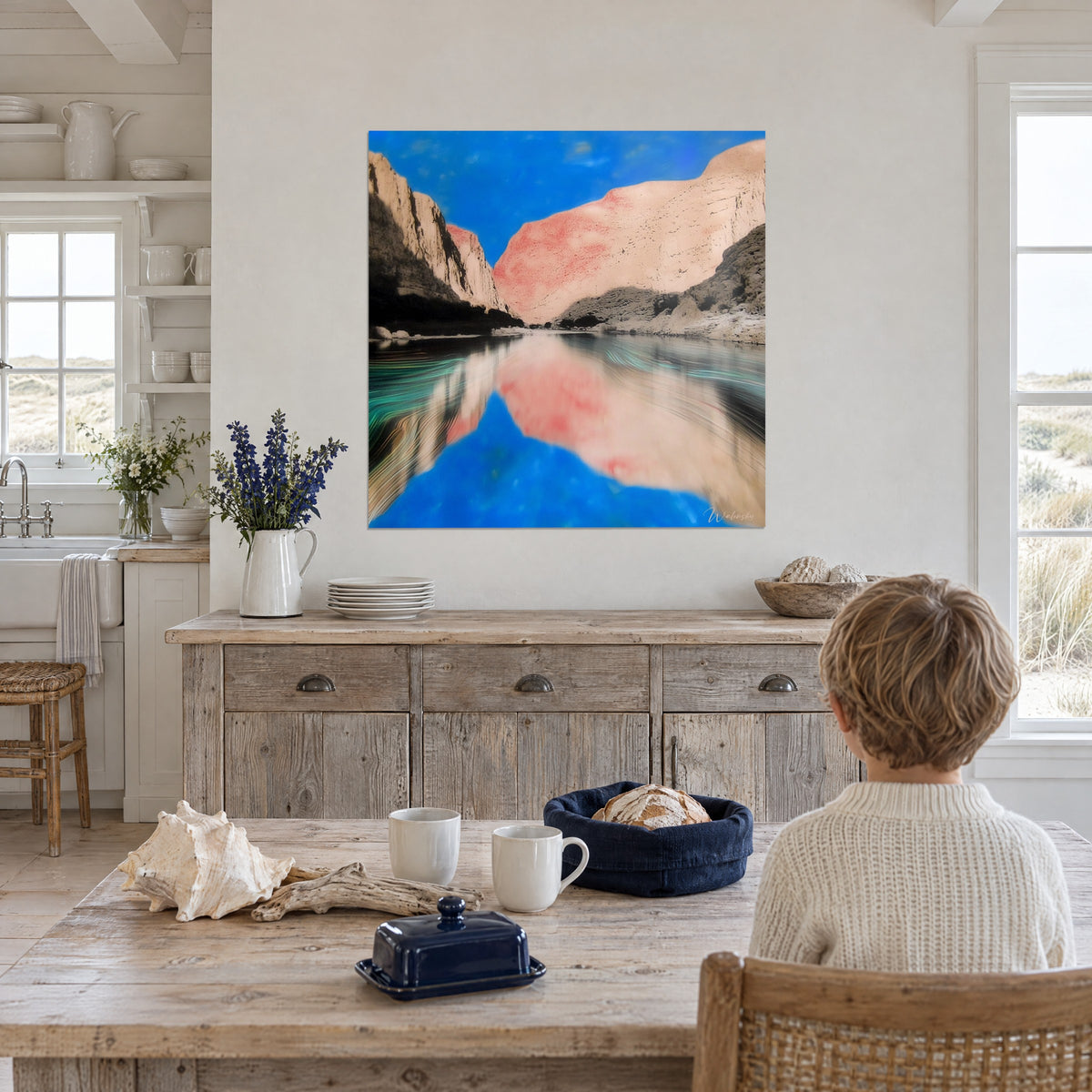 Schilderij rivier tussen twee wanden van roze en beige zandsteen, helderblauwe lucht, tegenover een kind dat aan tafel zit in een keuken aan zee