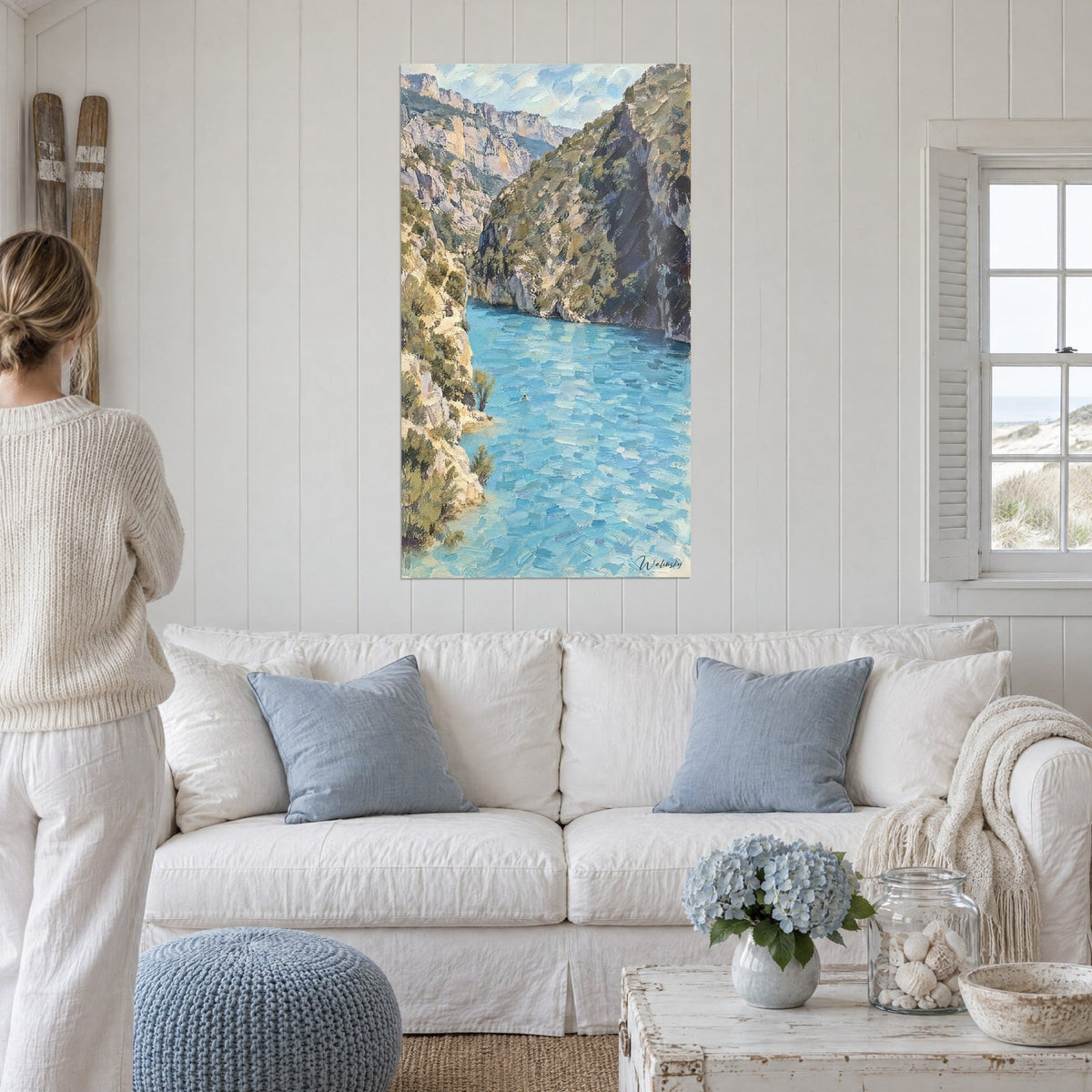 Gemälde Verdon-Schlucht in Öl gemalt, türkisfarbenes Wasser zwischen beige und olivgrünen Felswänden, über einem Sofa in einem hellen Wohnzimmer