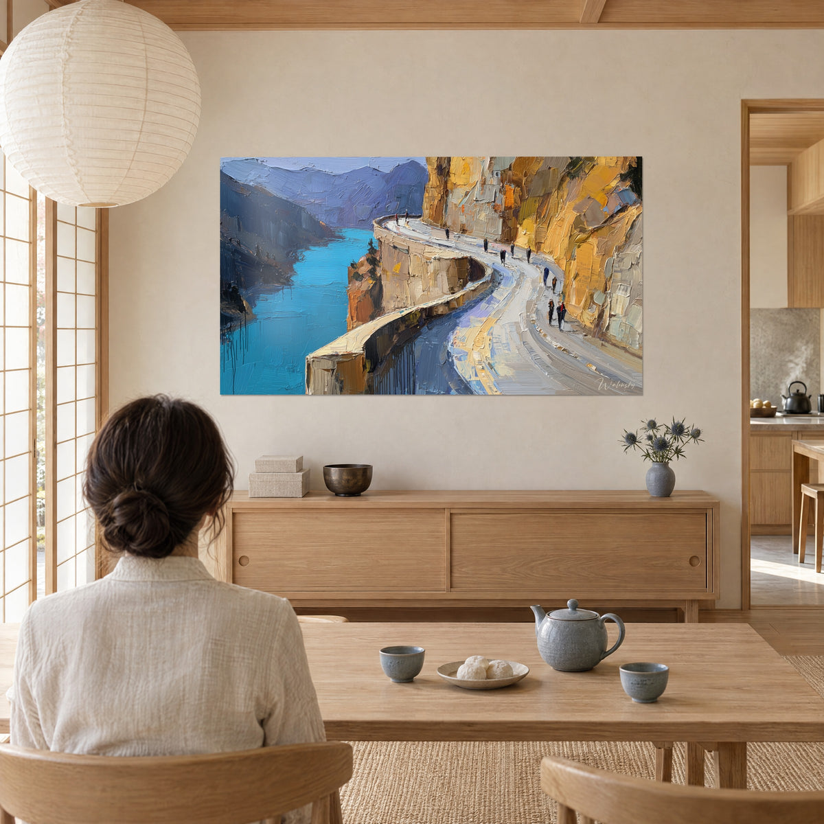 Tableau lac turquoise encaissé entre roche jaune et montagnes mauves, vu depuis une table basse où fume une théière, salon japandi