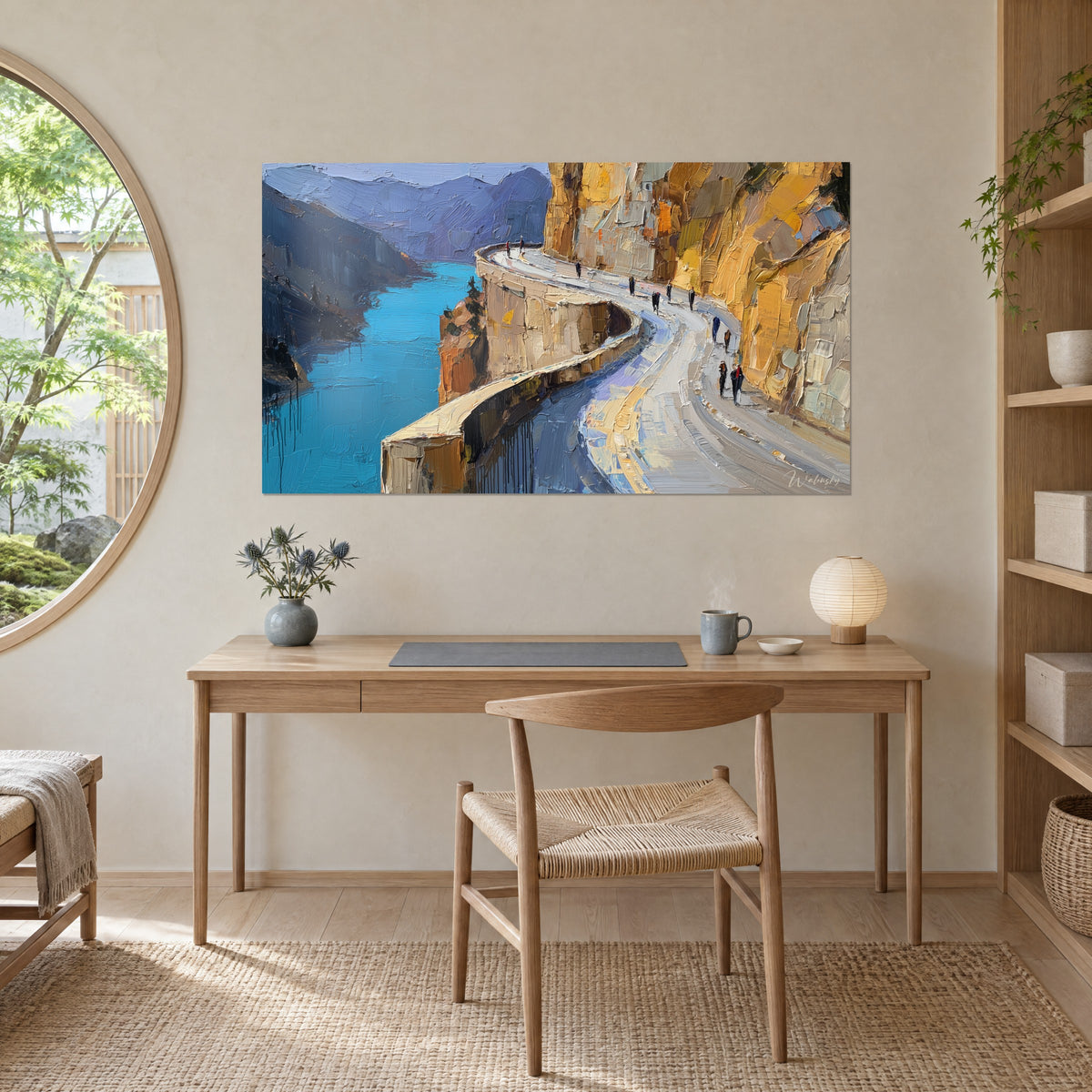 Tableau promeneurs minuscules sur un ruban de route grise, falaise miel et eau azur, face à un bureau en bois clair
