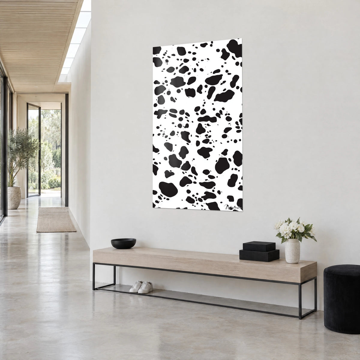 Cuadro con estampado de dálmata en gotas negras sobre blanco brillante, vista de tres cuartos, encima de un banco beige y negro