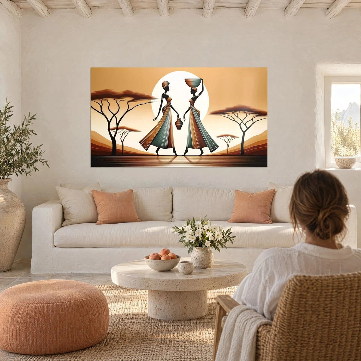 Tableau deux porteuses africaines en robes rayées ocre et vert sauge devant un soleil blanc, au-dessus d'un canapé dans un salon lumineux