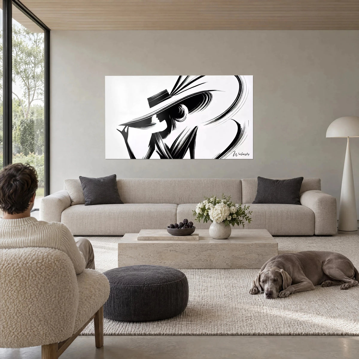Gemälde einer weiblichen Silhouette unter einem breiten schwarzen Hut, Feder in Schwüngen auf weißem Grund, über einem Sofa in einem hellen Wohnzimmer