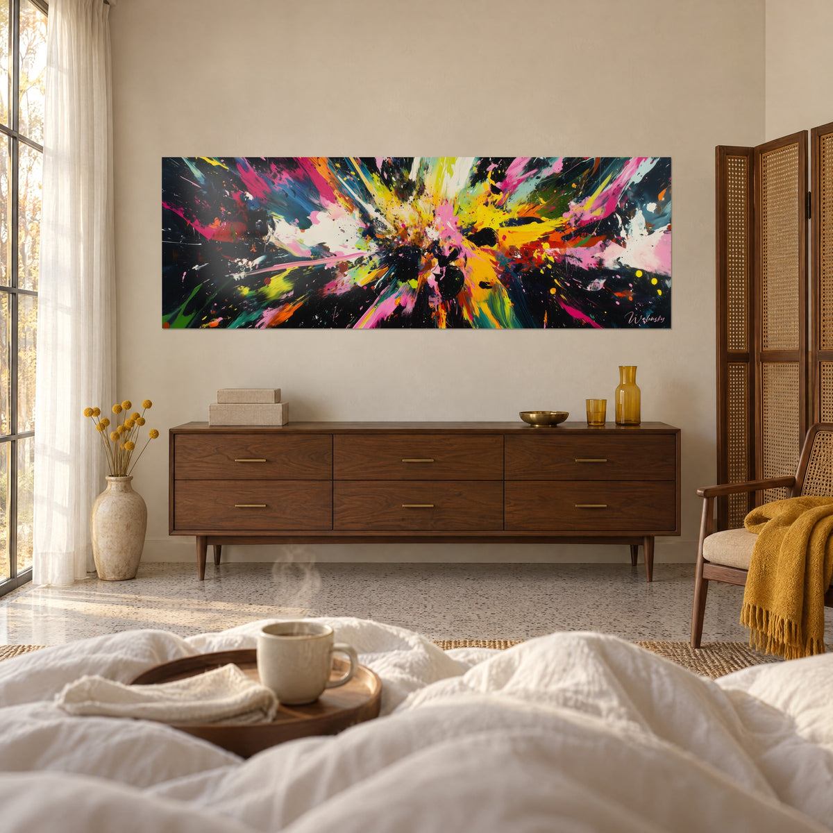 Cuadro deflagración de colores fluorescentes, destellos rosas y amarillos sobre negro, sobre una cama en un dormitorio claro