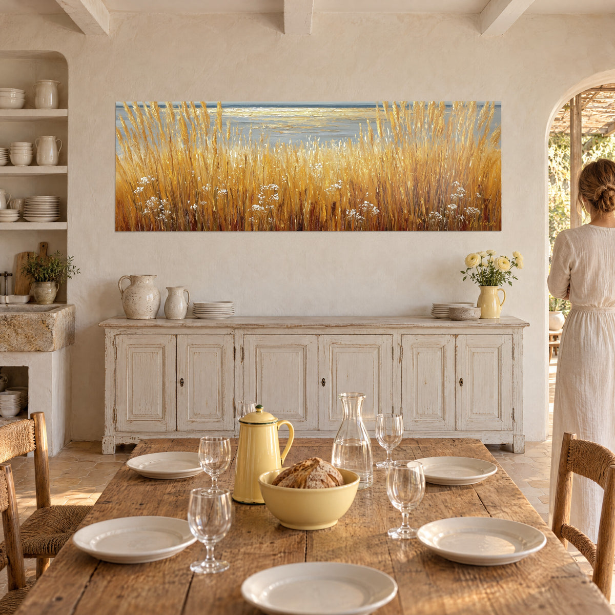 Gemälde goldene Ähren reliefartig vor einem blassen Meer, kupferne Reflexe und cremiges Weiß, provenzalisches Esszimmer, Frau von hinten