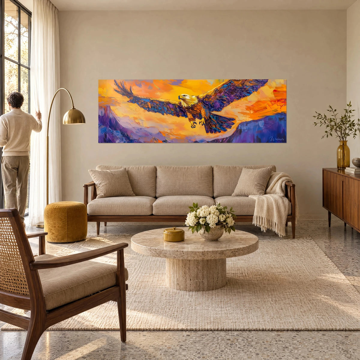Tableau rapace aux ailes violettes déployées sur ciel orange, homme de dos, au-dessus d'un canapé dans un salon lumineux