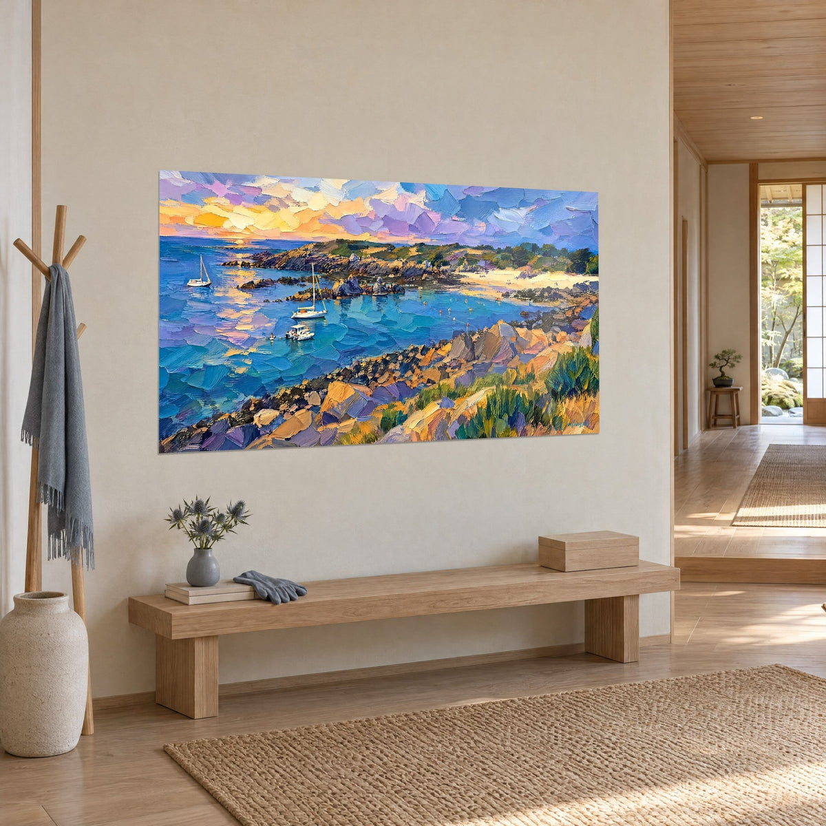Wall art of a Breton bay at sunset, azure blue water, ochre cliff and pale beach, hung in the entrance of a japandi home